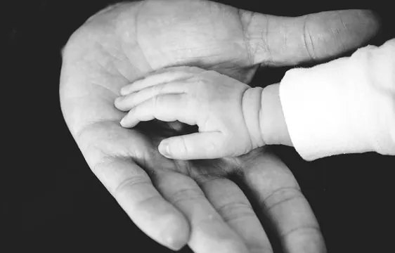 child's hand in a parent's hand